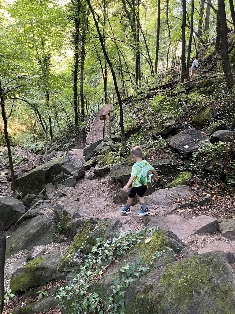 Kind steigt über Felsstufen in der Klamm