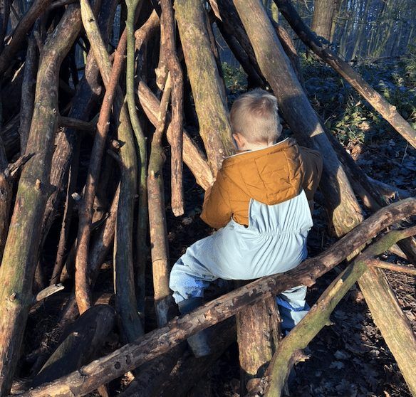 Kleinkind im Baumstamm-Tipi im Wald am Tannenbusch Dormagen